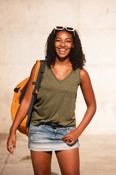 Smiling teenager with backpack in sunny outdoors