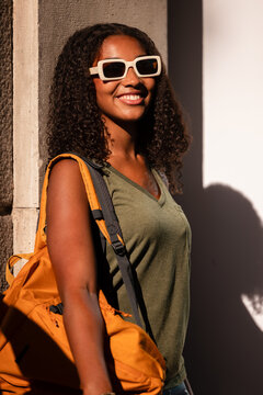 Teenage girl with backpack and sunglasses in sunny setting