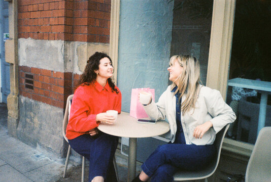 Friends Enjoy Chatting at Outdoor Cafe in City
