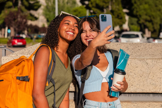 Happy teenage girls taking selfie with school gear