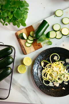Zucchini spaghetti on dark plate with fresh ingredients
