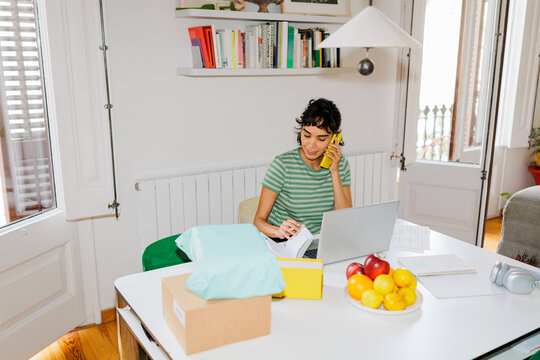 Woman working from home, managing packages and orders ugc