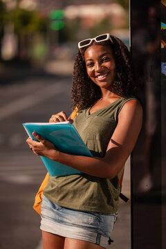 Smiling student outdoors with school accessories