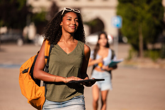 Teenage girls with school accessories walking outdoors