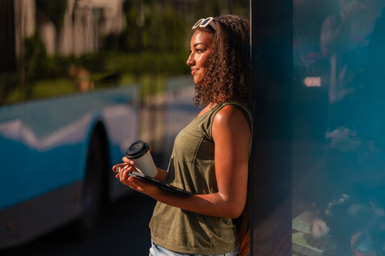 Teenage girl with school accessories waiting at bus stop