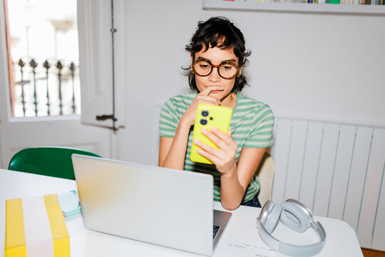 Woman browsing information on a smartphone at home ugc