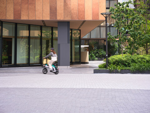 Bicycle Rider Moves Through Modern Business District in Osaka, Japan