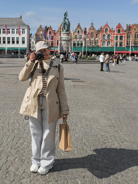 Woman Tourist with Camera in Public Square of Bruges Belgium