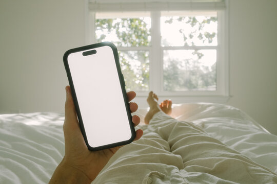 Checking phone in bed after waking up