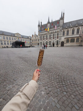 POV of Tourist Holding Chocolate Waffle in Bruges Belgium Square
