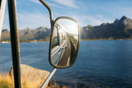 Camper van reflecting in side mirror during road trip
