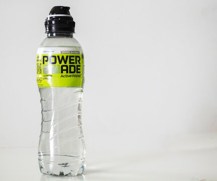 A single clear plastic bottle of "Powerade Active Water" Zero Sugar, Lemon Lime flavour, with a black sports cap, displaying the bold logo and brand on a neon yellow label.