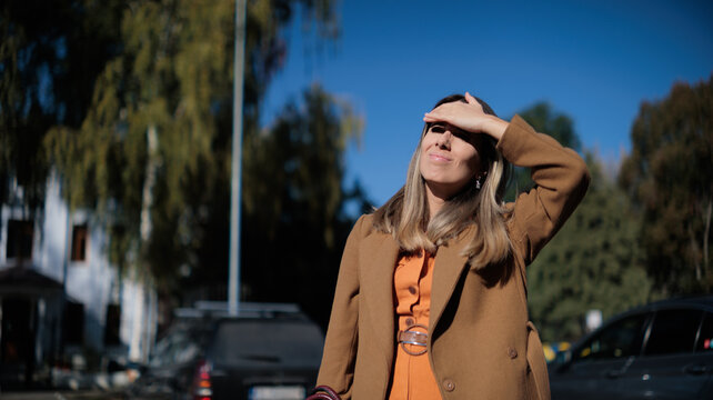  Woman Squinting And Shielding Her Eyes From Bright Autumn Sun Outdoors. Anxious lady struggling with strong sunlight glare using her hand to shade forehead 