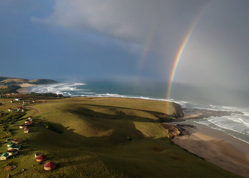 Wild coast landscape showing double rainbow over ocean