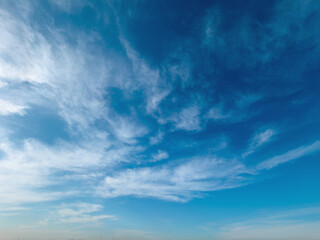 Obraz premium Sweeping wispy clouds create dramatic patterns across an expansive vivid blue daytime sky