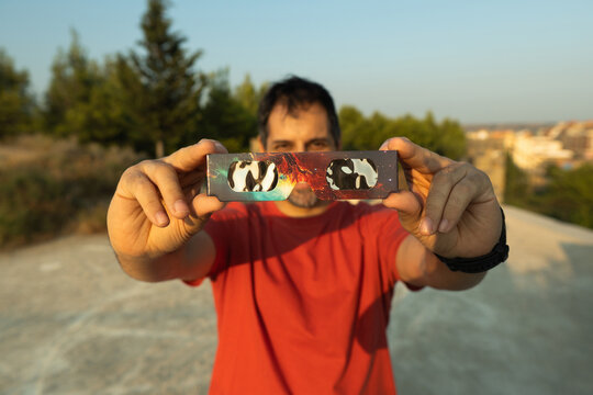 Man holding solar eclipse glasses for safe viewing