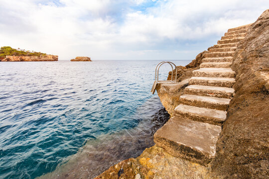 Stone stairs and metal ladder in Cala d'Or, Mallorca, Spain.