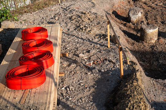 Red construction coils on wooden planks at building site