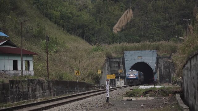 Passenger train emerging from a mountain railway tunnel in Haflong, Dima Hasao district, Assam, India. 