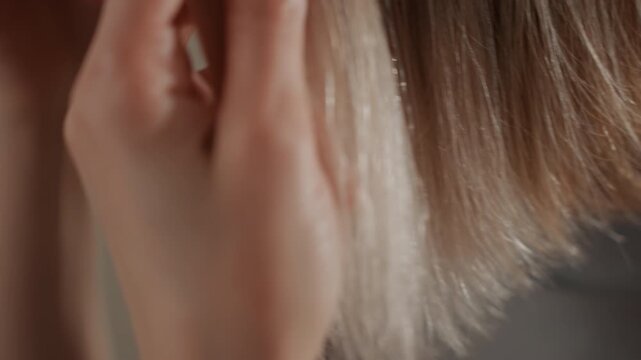 Caucasian woman music lover touching ends closeup, fingertips exploring blonde bob tips, subtle backlight shimmer, soft movement, neck caress, playful intimate study of texture, cinematic mood