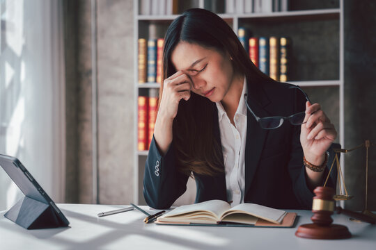 Tired Asian Lawyer Woman Feeling Stressed with Headache at Desk Working on Legal Case Court Document Law Firm Attorney Justice Gavel