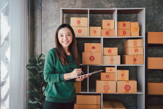 Asian Adult Woman Manages Online Business Stock Checking Orders for Delivery E Commerce Store Packaging and Shipping Service Small Business Concept
