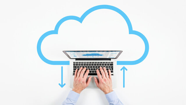 Top Down View of Person Typing on Laptop with Blue Cloud Outline Symbolizing Cloud Computing and Data Transfer