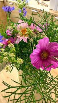 Wildflower bouquet on a wooden table bathed in soft natural light evoking summer country charm suitable for editorial, lifestyle blogs, social media, and product catalog use