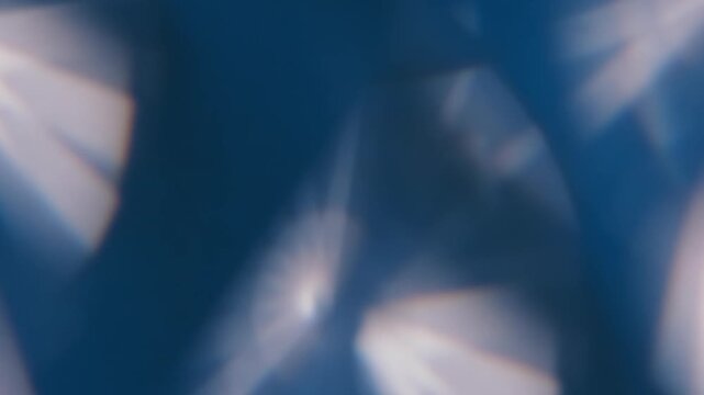 Blur optical twinkle. Glimmer art. Defocused blue white color lens flare round kaleidoscope floating on light visual abstract background.