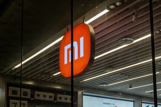 Illuminated orange Xiaomi Mi logo sign in retail store