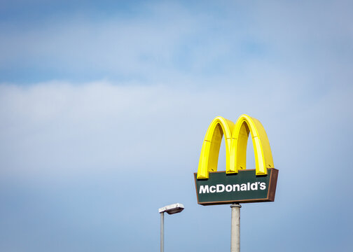 McDonald's Logo vor blauem Himmel mit Wolken.