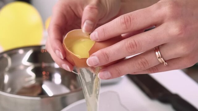 Protein recipe. Separating yolk. Female chef hand cracking raw egg shell on kitchen table cooking healthy natural ingredient meal.