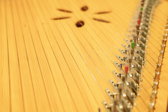 Close up of strings and tuning mechanism of traditional hammered dulcimer