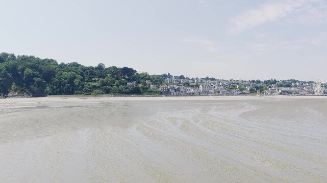 A wide, bright summer view of the sandy beach and coastal town of Binic, Brittany, France.
