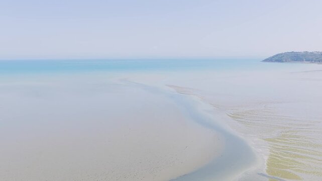 Aerial view of Binic beach on the Brittany coast of France, captured at low tide in summer.