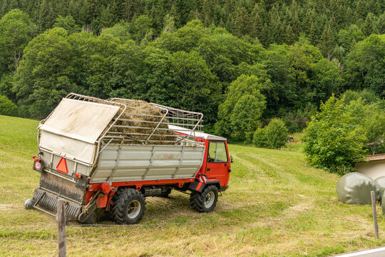 Gadmen, Switzerland. Agricultural utility vehicle transporting hay on an alpine meadow in the Swiss Alps