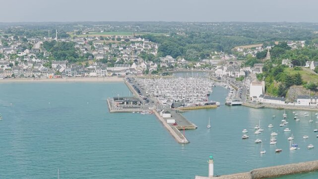 A high-angle aerial shot of the marina and waterfront in Binic, a coastal town in Brittany, France.