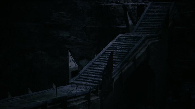 Weathered stone stairs flanked by banner and broken parapet, defensive architecture hints at former stronghold, windscarred surfaces and moss growth emphasize