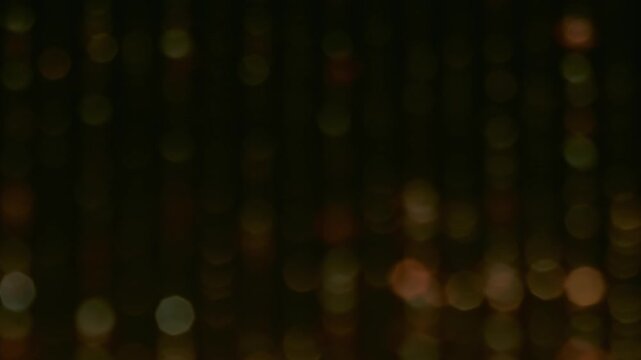 Shimmering dots. Color twinkle blur. Light defocused circles stripes glow fade flicker. Abstract bokeh night luminosity background.