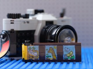 Fototapeta premium Tambov, Russian Federation - February 20, 2026 Lego Creator Retro Camera with film strip accessory with colorful printed scenes in front of it