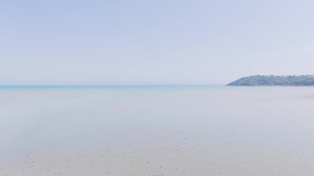 A tranquil panoramic view of the sandy beach and calm sea at Binic, located in Brittany, France.