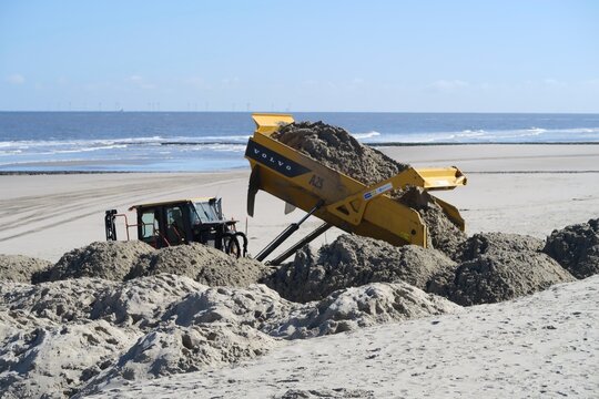 Wangerooge, Niedersachsen, Deutschland - 04 07 2026: Ein Kipplaster sch&uuml;ttet Sand vom Osten der Insel auf den Hauptstrand der Insel Wangerooge. Die Winterst&uuml;rme haben viel Sand abgetragen.