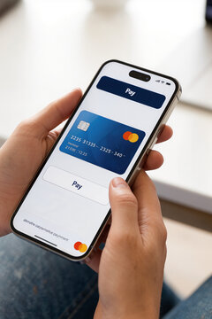 Visa payment card displayed on smartphone while hand presses Pay button, illustrating mobile banking, digital commerce, secure transaction technology services.
