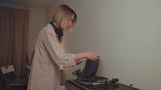 Woman spins records with rhythm. Woman identifies as DJ performing intimate night musical set. Female music selector skillfully mixes vinyl records during intimate home concert setting
