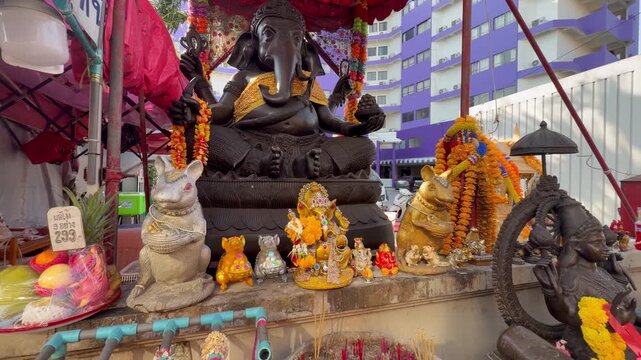 PATTAYA, THAILAND - APRIL 2026 : Close-up shot of Ganesha statue along busy Soi Buakhao nightlife street. Traditional Thai religion culture and local worship faith.