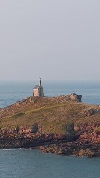 A wide view of the Ilot Saint Michel and its historic chapel, located off the coast of Erquy in Brittany, France.
