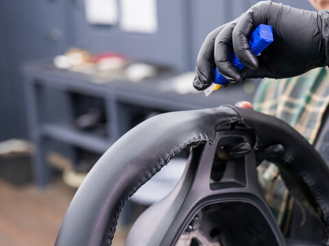 The mechanic changes the cover on the car steering wheel.