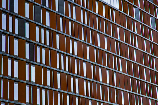 Modern building facade with brown corten steel panels and glass windows background pattern