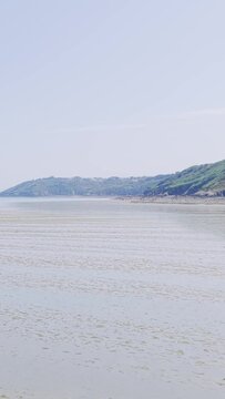 A wide, tranquil view of Binic beach on the Brittany coast in France, captured at low tide.