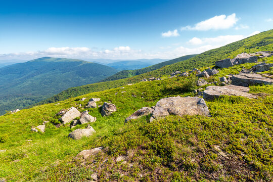 mountain landscape with grass and rock on a slope. view in to the distant valley of carpathian mountains. mountainous scenery of ukraine in summer. green environment concept for poster